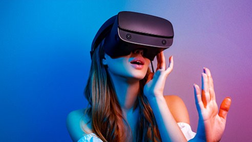Woman wearing VR headset interacting with immersive virtual environment